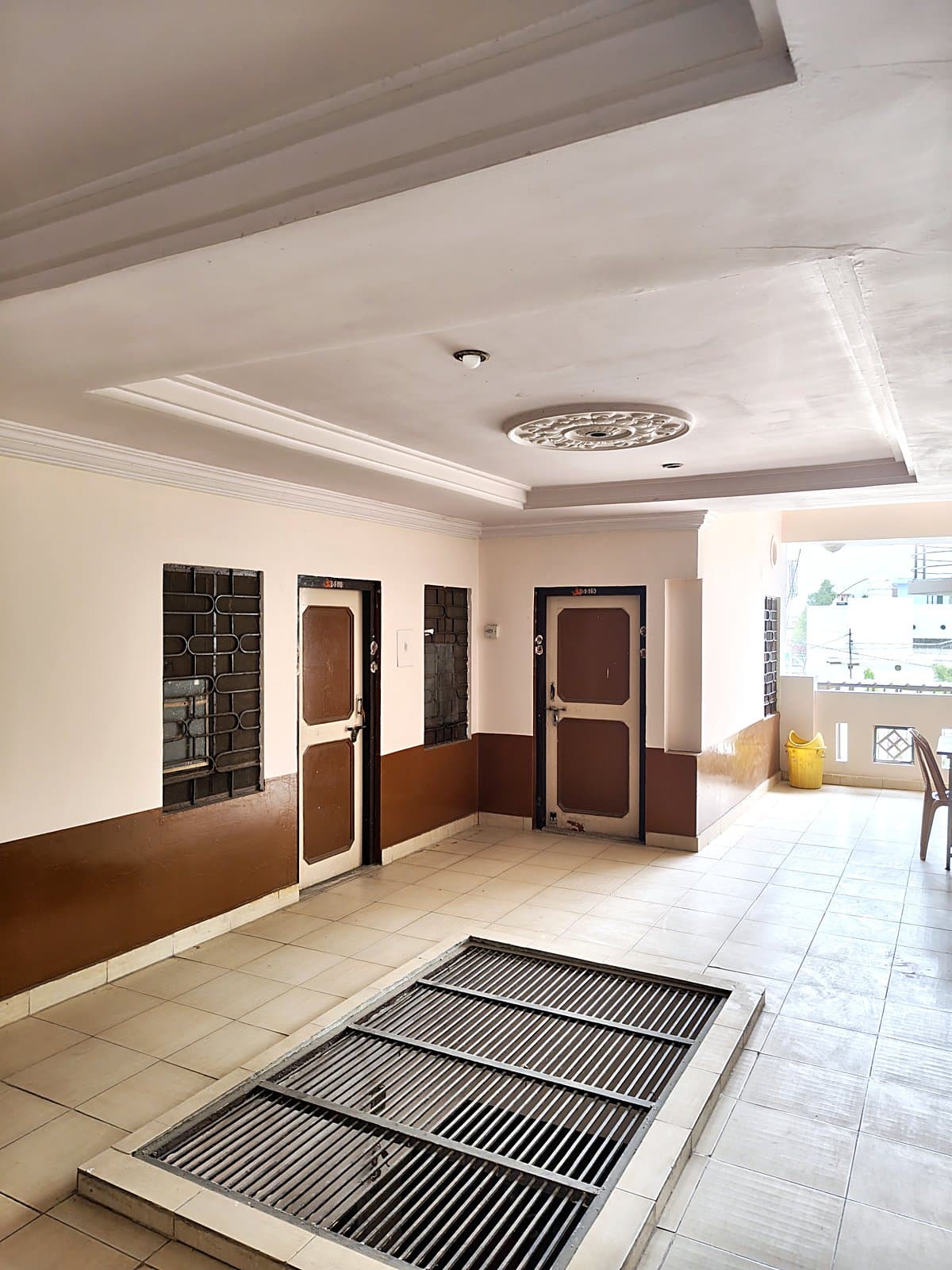 Covered common corridor inside Sharma Girls Hostel with room doors and tiled flooring